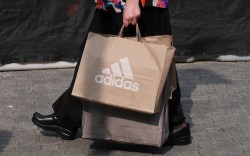 A person carries a bag from the adidas store at the Woodbury Common Premium Outlets shopping mall on August 26, 2018 in Central Valley, New York.