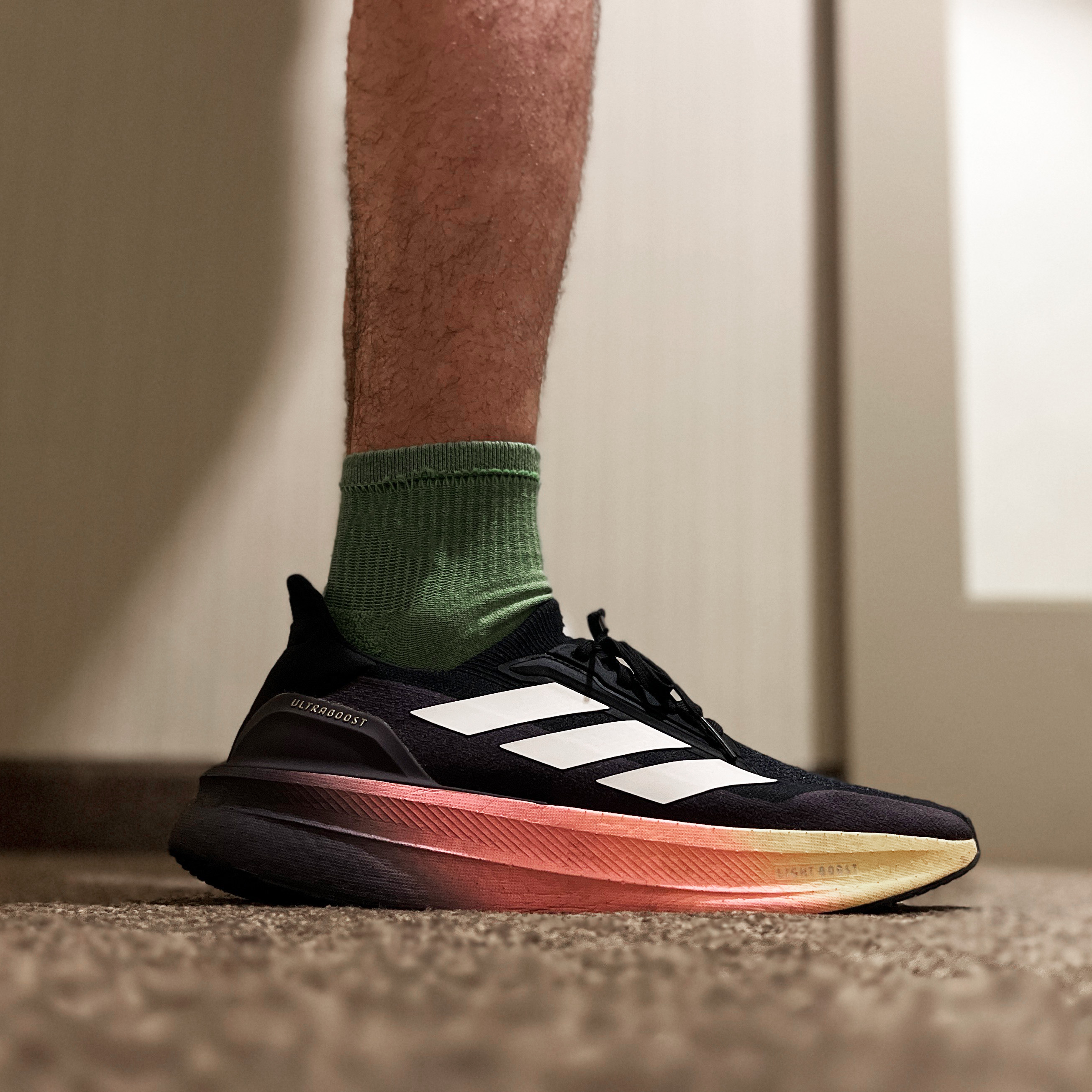 man wearing black and white striped running sneakers with green socks