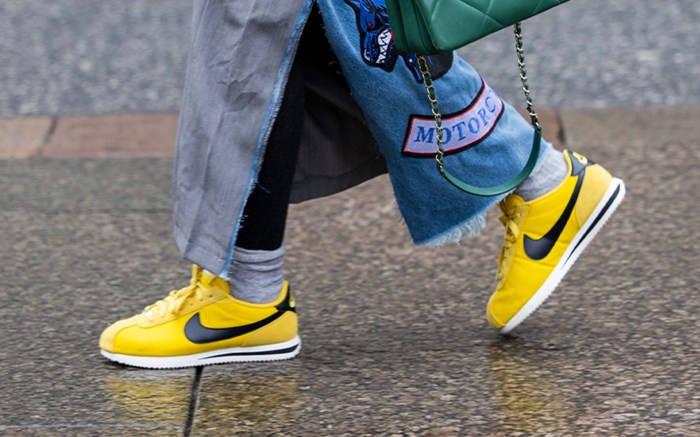 person wearing yellow sneakers with socks and a denim skirt