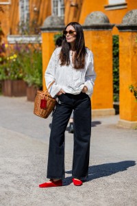 COPENHAGEN, DENMARK - AUGUST 07: Ana Cerrato wears basket bag, black denim jeans, white blouse outside Skall Studio during day three of the Copenhagen Fashion Week (CPHFW) SS25 on August 07, 2024 in Copenhagen, Denmark. (Photo by Christian Vierig/Getty Images)