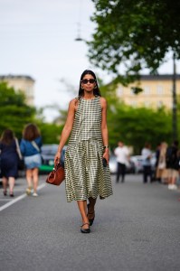 COPENHAGEN, DENMARK - AUGUST 7: Miriam Akosua Nehring, Vogue Germany Senior Editor, wears black sunglasses, gold earrings, black and white pattern midi dress, dark brown leather bag, black bracelet, shiny black ballerina flats, outside Baum und Pferdgarten, during the Copenhagen Fashion Week Spring/Summer 2024-2025 on August 7, 2024 in Copenhagen, Denmark. (Photo by Edward Berthelot/Getty Images)