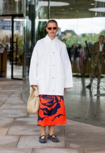 COPENHAGEN, DENMARK - AUGUST 08: Hollie Mercedes Peters wears white oversized button shirt, beige Bottega Veneta bag, red skirt with print outside Marimekko during day four of the Copenhagen Fashion Week (CPHFW) SS25 on August 08, 2024 in Copenhagen, Denmark. (Photo by Christian Vierig/Getty Images)