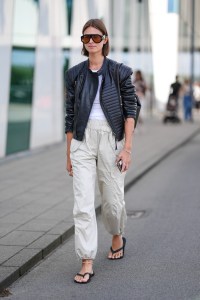 COPENHAGEN, DENMARK - AUGUST 8: A guest wears black sunglasses, white t-shirt, black biker leather jacket, light brown cargo pants, silver bracelet, silver rings, black flip flops, outside Munthe, during the Copenhagen Fashion Week Spring/Summer 2024-2025 on August 8, 2024 in Copenhagen, Denmark. (Photo by Edward Berthelot/Getty Images)