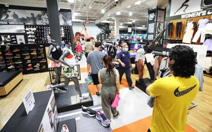 GARDEN CITY, NEW YORK - JULY 10:  Customers wait in line to pay for itemsat Dick's Sporting Goods store at Roosevelt Field Mall which reopened today on July 10, 2020 in Garden City, New York.  Malls across the state were ordered to close March 19, and other businesses deemed nonessential were ordered to close the same week, to help stop the spread of the coronavirus.  The openings follow Gov. Andrew M. Cuomo’s announcement Wednesday that malls outside of New York City can open if they have high-efficiency air filtration systems to help control the spread of the virus.   (Photo by Al Bello/Getty Images)